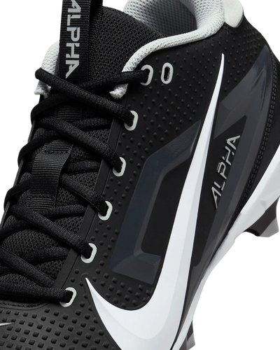 Primer plano del taco de fútbol americano Nike Alpha Menace Varsity 4 negro con swoosh blanco y cordones, diseñado para movimiento natural y amortiguación.